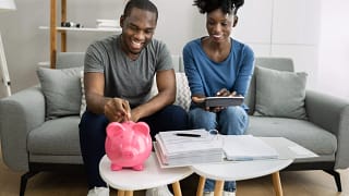 couple saving money in pink piggy bank.jpg