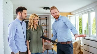 couple looking at house with realtor.width .jpg