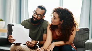 couple with bills signing papers.width .jpg