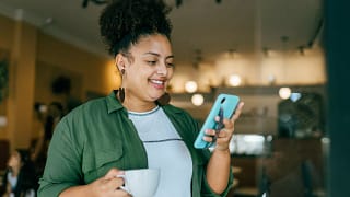 getty happy looking at phone smiling success winning.jpg