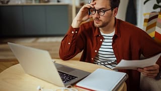 man s laptop holding head gettyimages .jpg