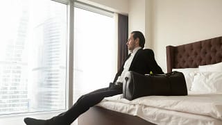 man in suit on hotel bed GCmlvmw.width .jpg