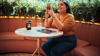 person at coffee shop table with phone JvOTB.width .jpg