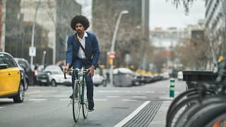 person riding bike on city street kTdlO.width .jpg