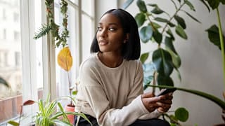 person with phone looking out window ZLNGso.width .jpg