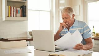 stressed person with papers and laptop UsCv.width .jpg