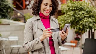 woman holding credit card and phone vpiLZ.width .jpg