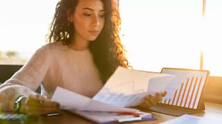 young woman sitting at a desk looking at charts.jpg
