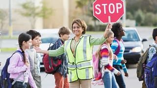 Crossing guard helping school children cross .width RDDdDn.jpg