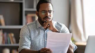 Man looking at documents with unsure expressi.width JzQldPC.jpg