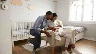 New parents holding baby in the nursery. Tca.width .jpg