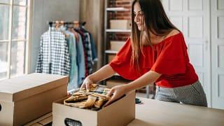 Woman boxing up some of her clothes. yDycw.width .jpg