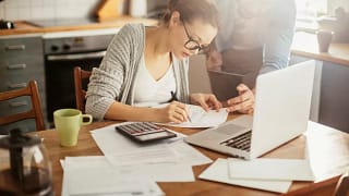 Woman with glasses making calculations VoscoL.width .jpg