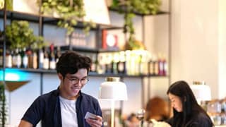 man in restaurant holding phone and credit ca.width UCoaDCF.jpg