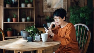 person sitting at a table using a smartphone.jpg