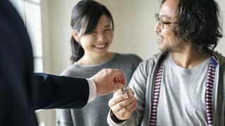 realtor handing couple house keys.width .jpg