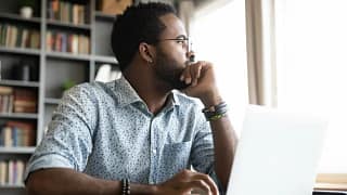 worried man at laptop looking out window.width .jpg