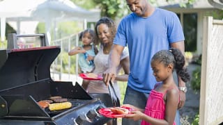 Family grilling hamburgers hotdogs and corn i.width .jpg