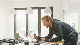 Man holding credit card and using laptop Hlq.width .jpg