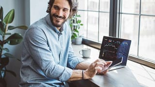 Man using laptop and cell phone to look at da.width qhRHKS.jpg