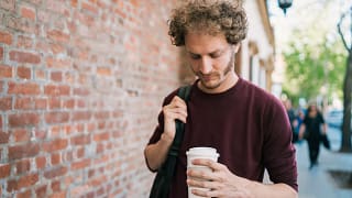 man s holding coffee to go gettyimages .jpg