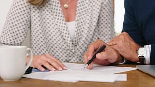 man and woman torsos signing document.jpg