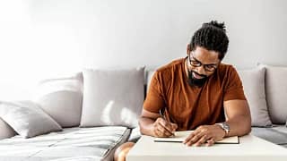man on couch writing in notebook YuEdzZp.width .jpg