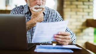older man serious looking at document gettyimages .jpg