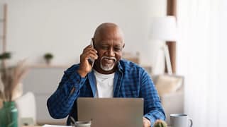 person talking on the phone and looking at a laptop.jpg