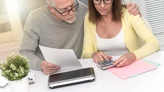 senior couple looking at calculator and documents.jpg