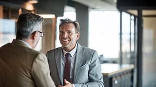 two people in business attire standing and talking gettyimages .jpg