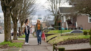 two people and baby walk down residential str.width lGpivdf.jpg