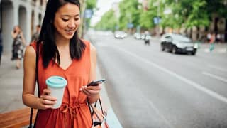 woman on street with phone and coffee.width .jpg