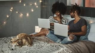 young couple on laptops in bedroom RrGguP.width .jpg