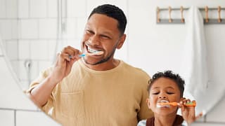 Adult and child brushing their teeth in front.width .jpg
