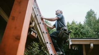 Man with tool belt climbing ladder to roof EJ.width .jpg