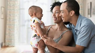 Parents smiling at infant JlkN.width .jpg