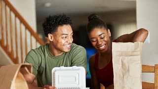couple opening takeout food at table GKcOR.width .jpg