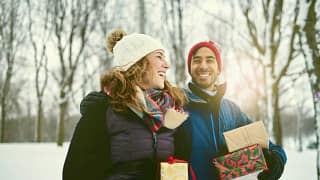 couple outdoors with holiday gifts.width .jpg