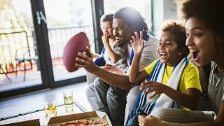 family on couch watching football vgiReM.width .jpg