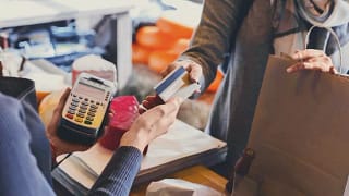 handing credit card to shop cashier.width .jpg