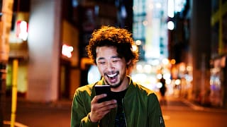 happy young man with smart phone at night.jpg