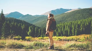 hiker admiring view of mountains and trees cP.width .jpg