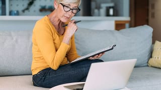 older woman at laptop holding clipboard gettyimages .jpg