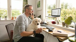 person on phone with dog on lap whDJ.width .jpg
