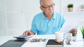 senior man document laptop calculator gettyimages .jpg