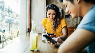 two people with phones in restaurant ZpfzLt.width .jpg