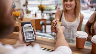 woman handing credit card to cofee shop cashi.width .jpg