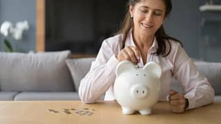 woman putting coins in piggy bank.width euqlYC.jpg