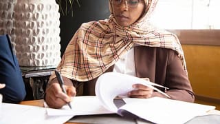 woman signing paperwork in office.width .jpg